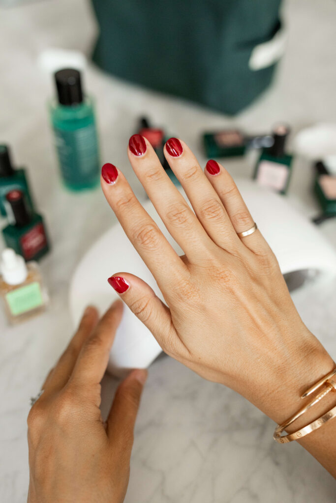 Camille Carter showing red gel nail polish on her fingernails