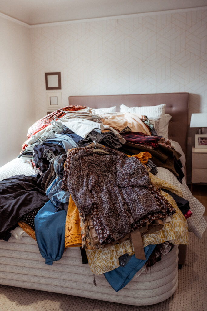 pile of clothes on bed, Marie Kondo method